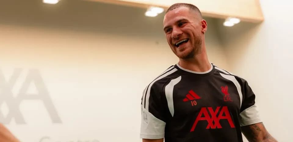 Player in Liverpool training kit smiling indoors