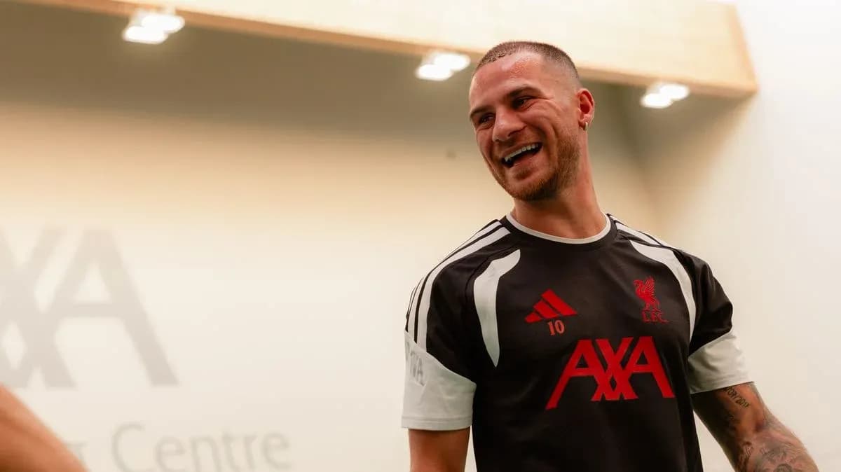 Player in Liverpool training kit smiling indoors