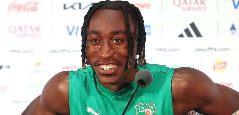 Player speaking at press conference in green jersey