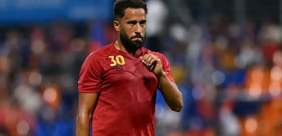 Player wearing red jersey during match warm-up