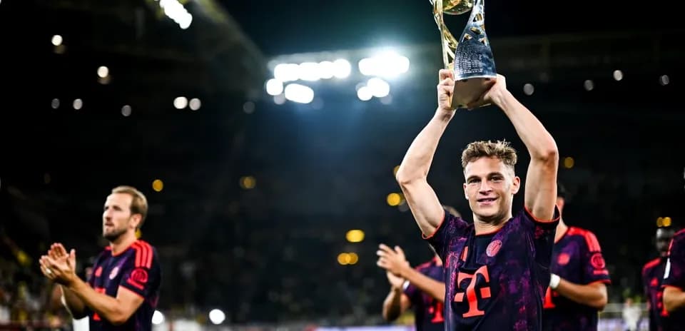 Player holding trophy with teammates celebrating