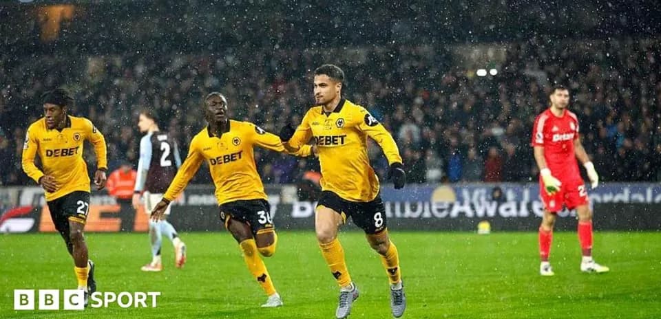 Player celebrating goal with teammates in snowy match
