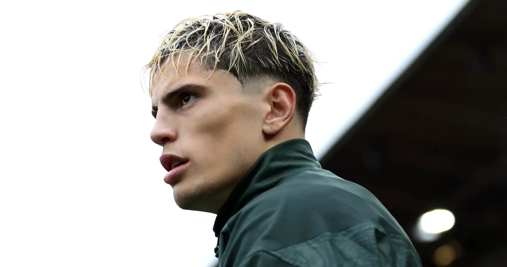 Player in training jacket looking off into distance