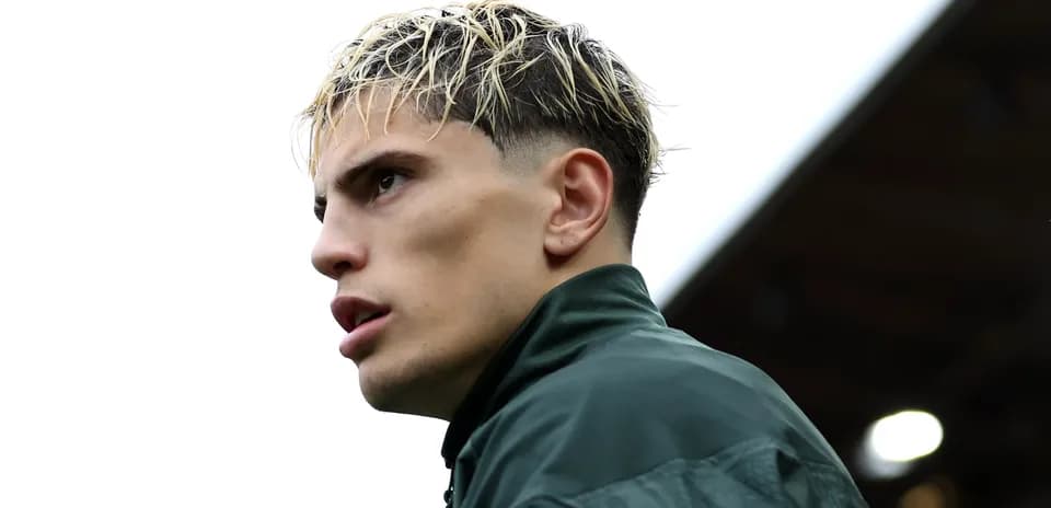 Player in training jacket looking off into distance