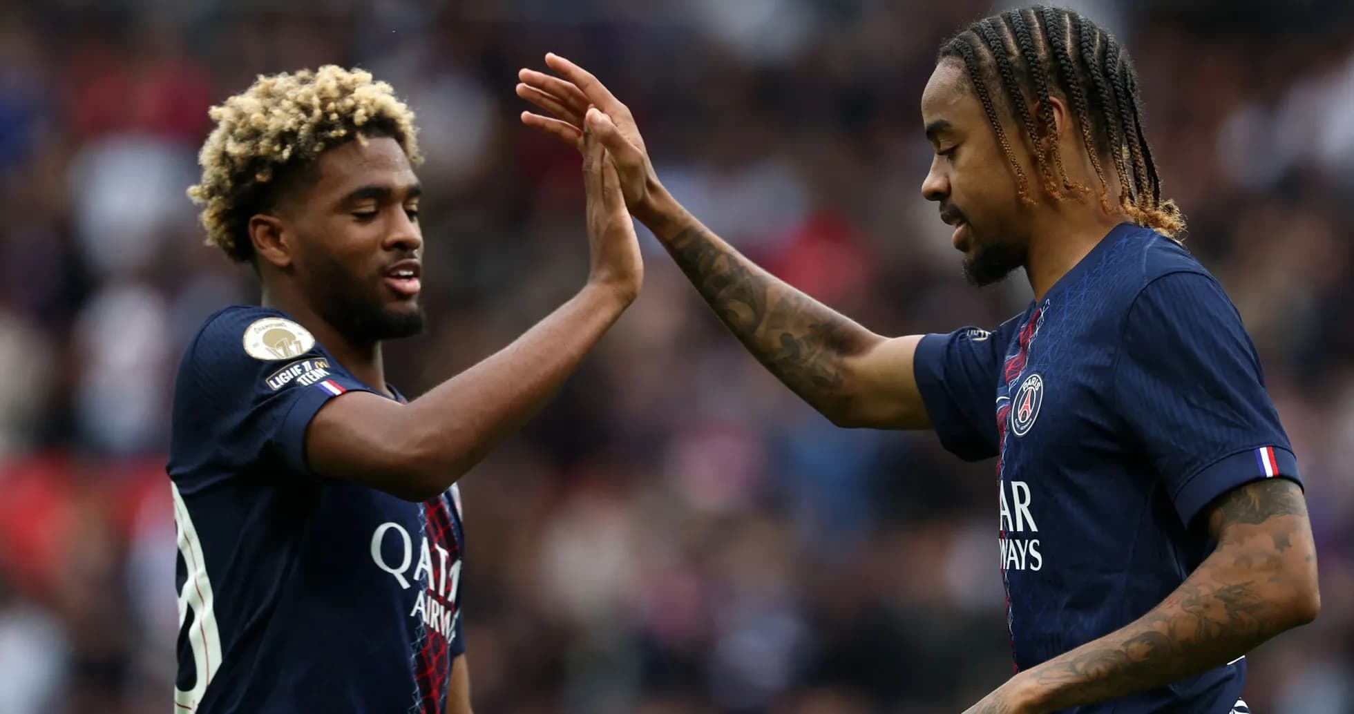 Two PSG players celebrating with a high five