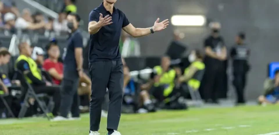 Coach gesturing during a soccer match on the sidelines