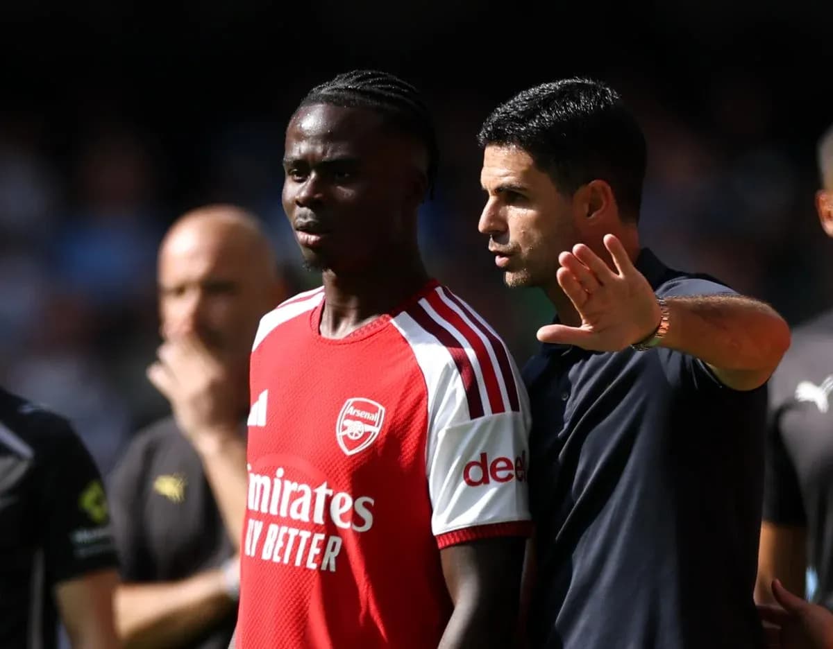 Arsenal coach discussing strategy with player on field Arsenal coach discussing strategy with player on field