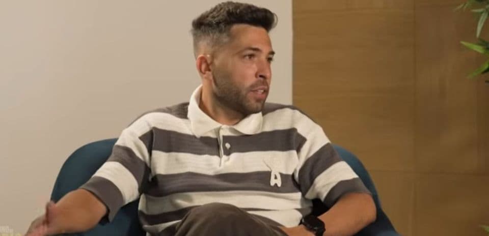 Person speaking during an interview on a couch