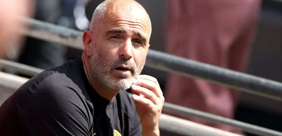 Coach observing from the sidelines during match