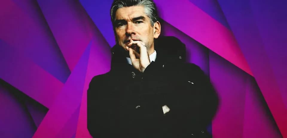 Man in coat posing against colorful background