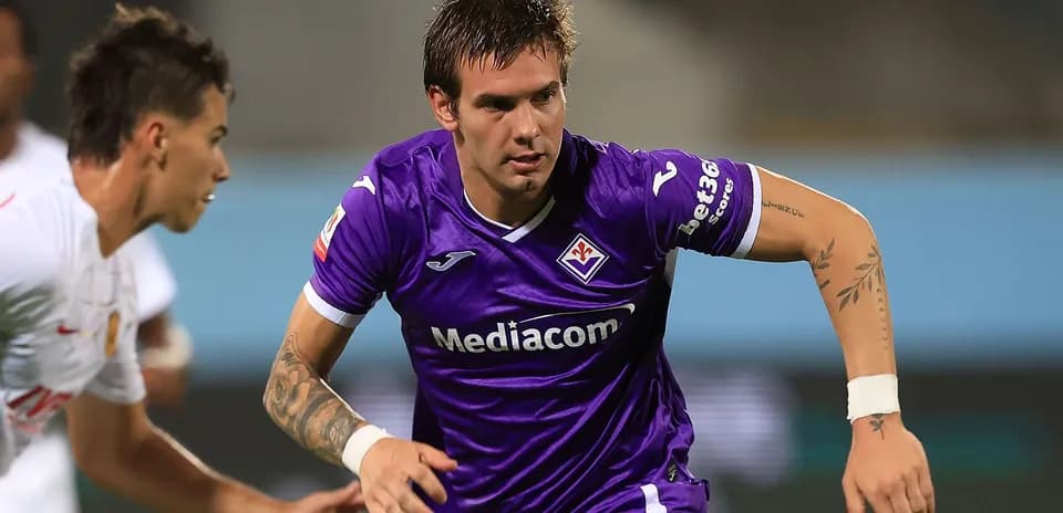 Player in purple jersey running with ball during match