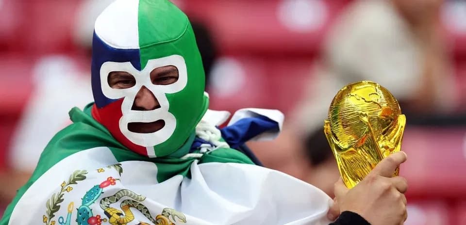 Fan wearing mask and holding World Cup trophy