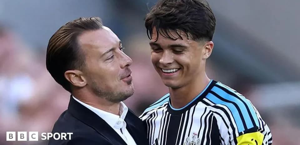 Coach and player smiling during post-match interaction