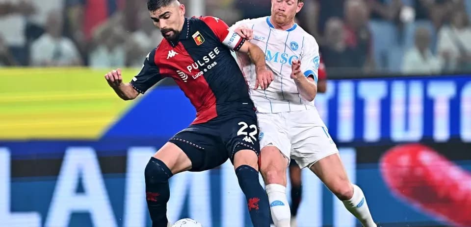 Genoa player challenged by Napoli player during match