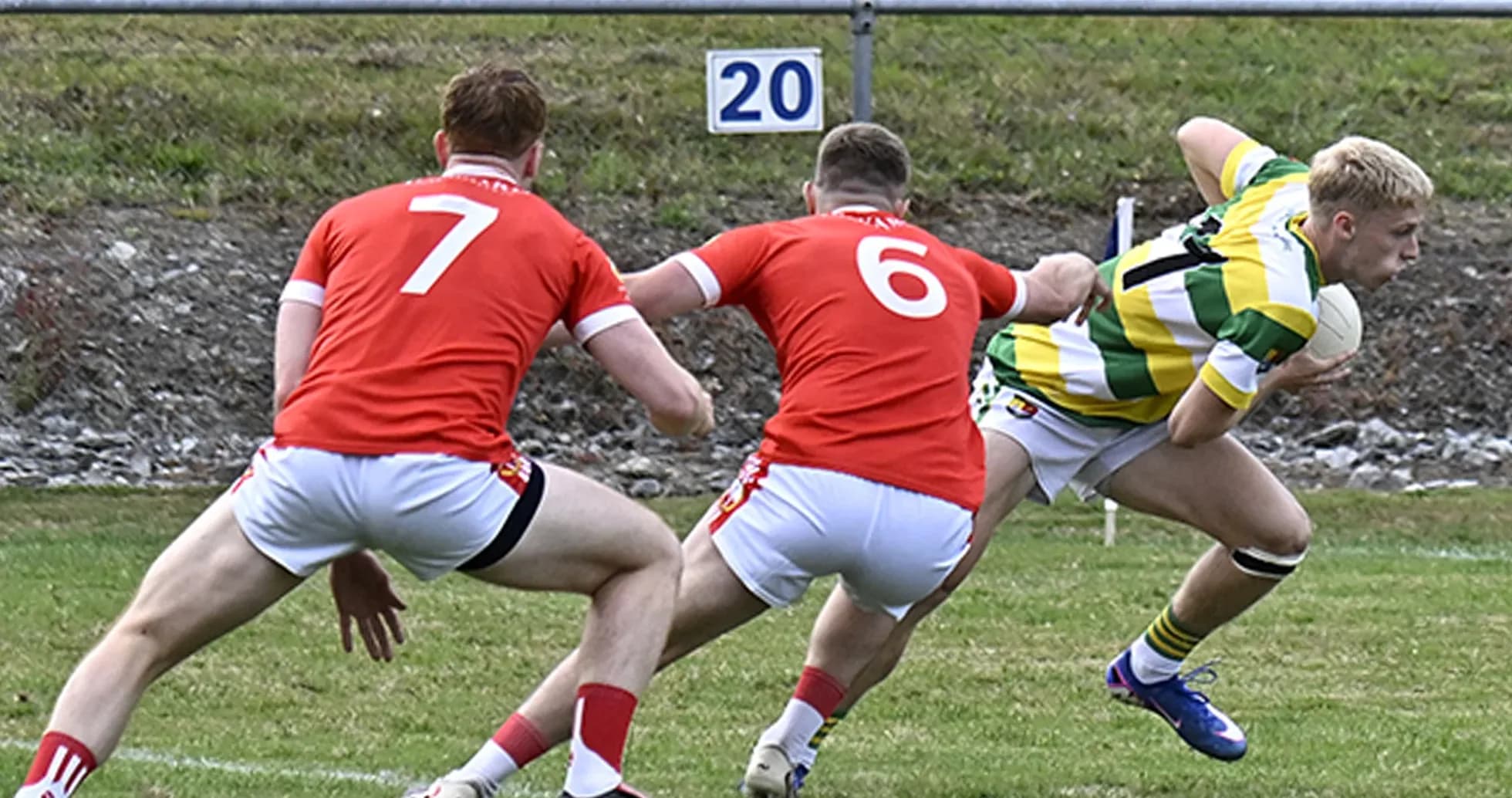 Player in striped jersey evading two defenders
