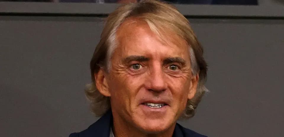 Man with long hair smiling at event