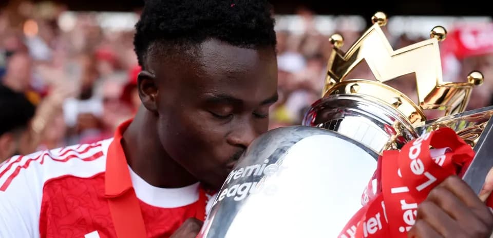 Player kissing Premier League trophy during celebration