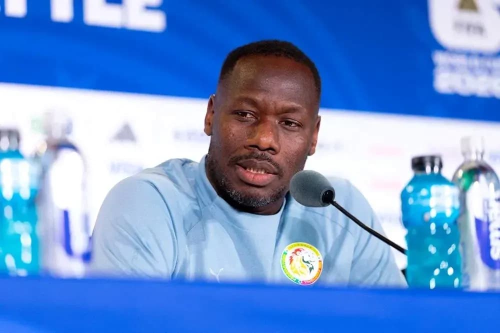 Coach speaking at press conference with water bottles