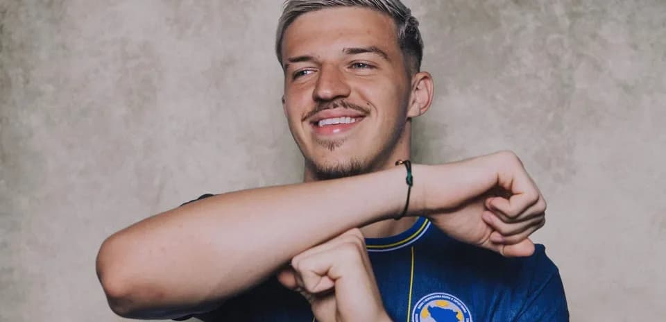 Player in blue jersey smiling and posing