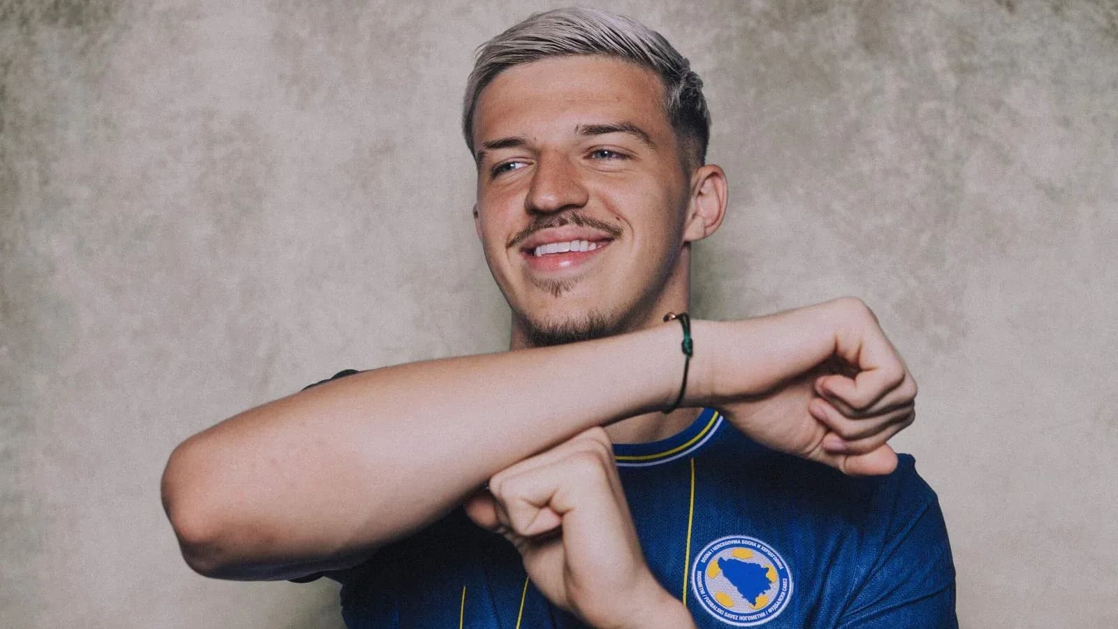 Player in blue jersey smiling and posing