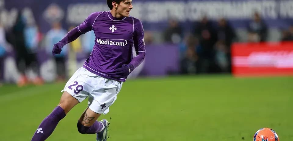 Player in purple kit running after soccer ball