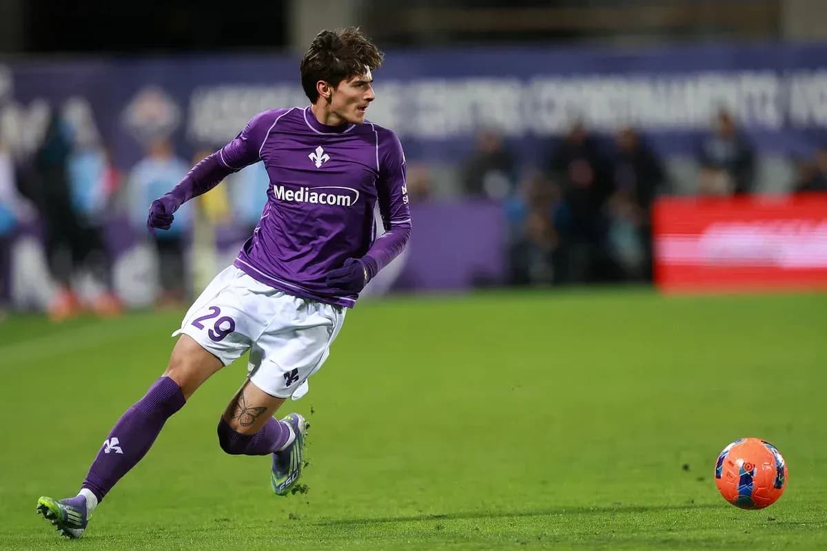 Player in purple kit running after soccer ball