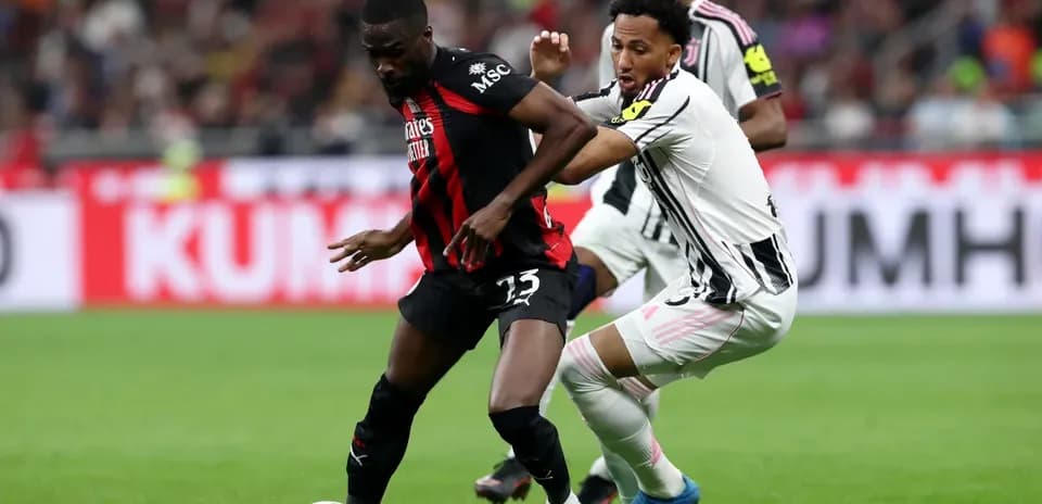 AC Milan player challenged by Juventus opponent