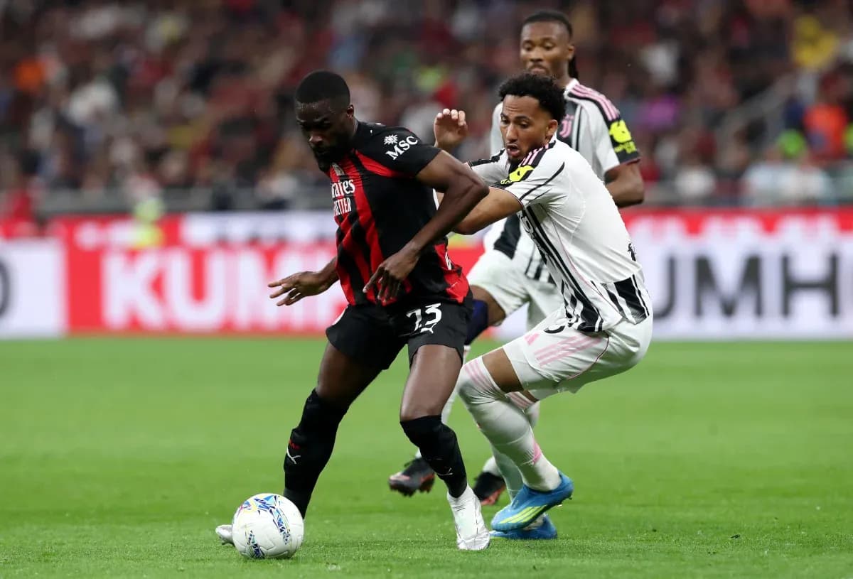 AC Milan player challenged by Juventus opponent