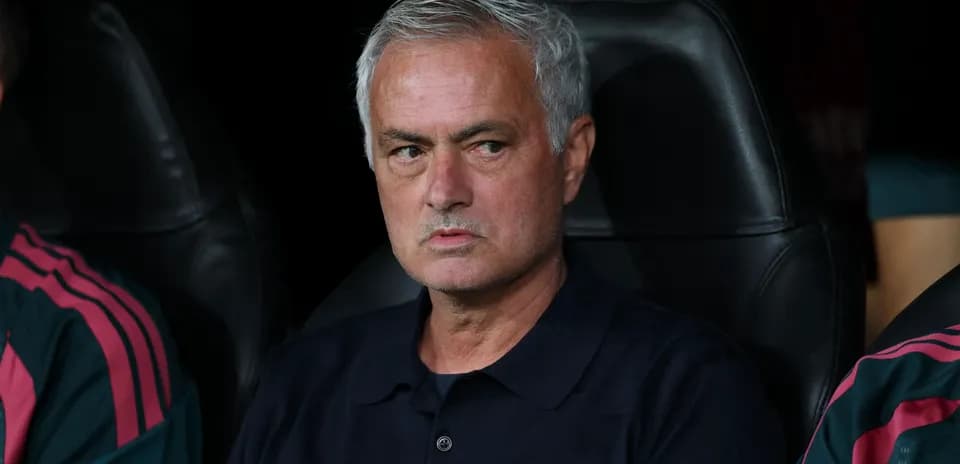 Manager sitting on bench during a match