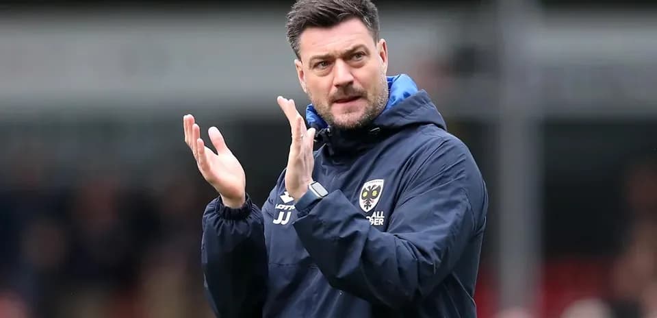 Manager clapping during a match on the sidelines