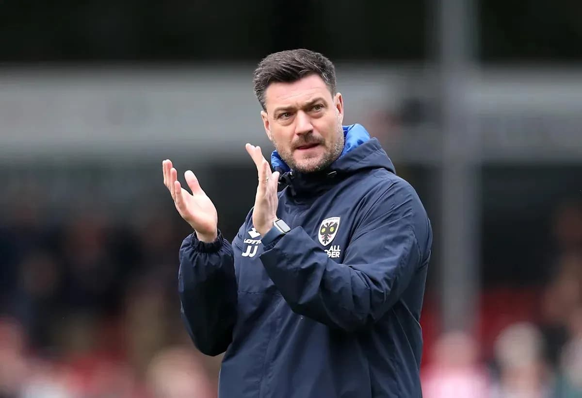 Manager clapping during a match on the sidelines