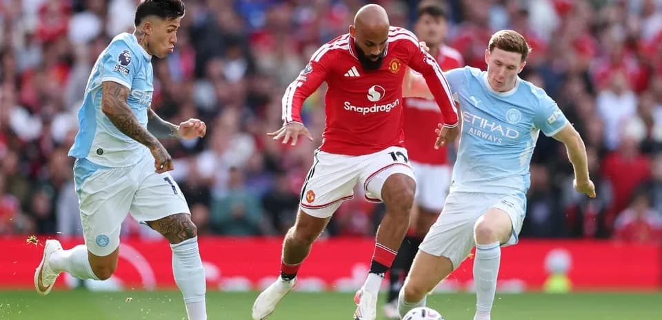 Manchester United player challenged by Manchester City opponents