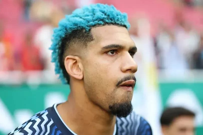 Goalkeeper with blue hair during pre-match warm-up