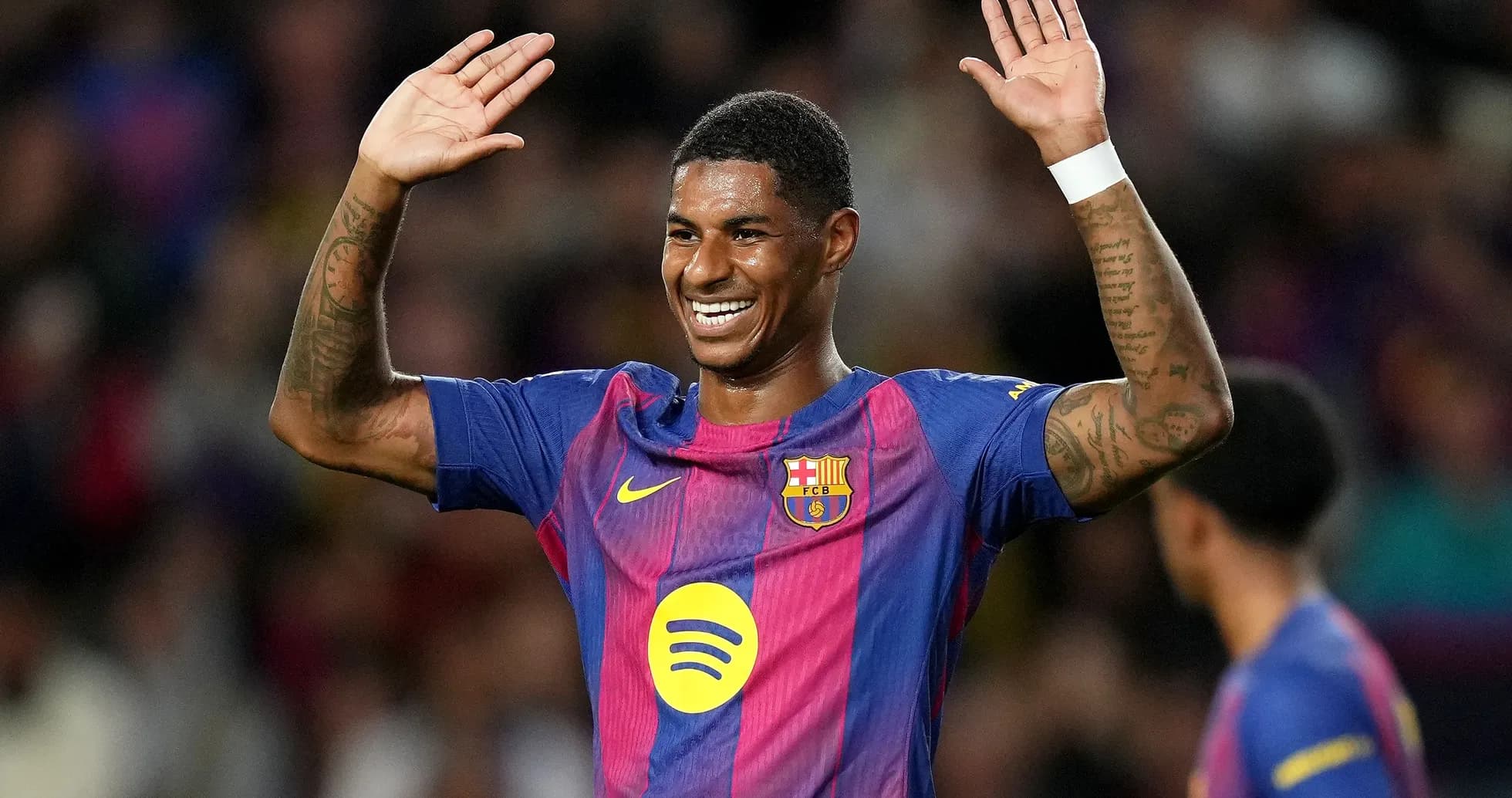 Player celebrating with raised hands in Barcelona kit
