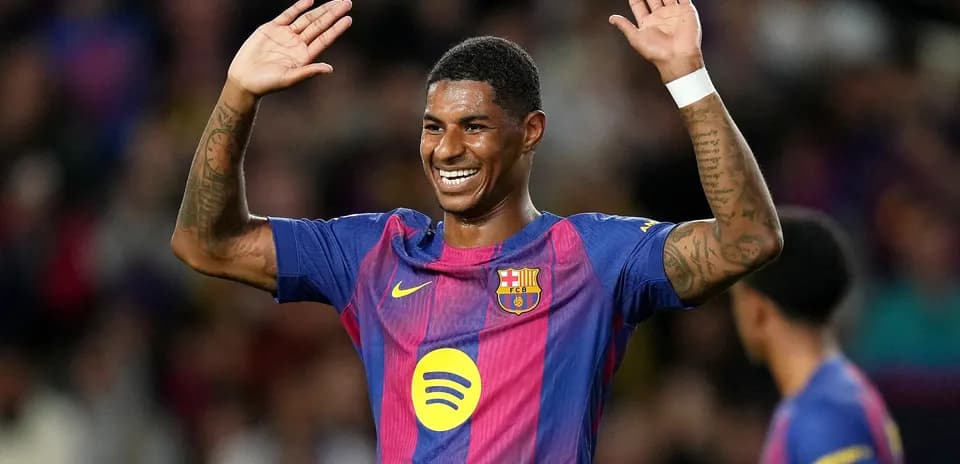 Player celebrating with raised hands in Barcelona kit
