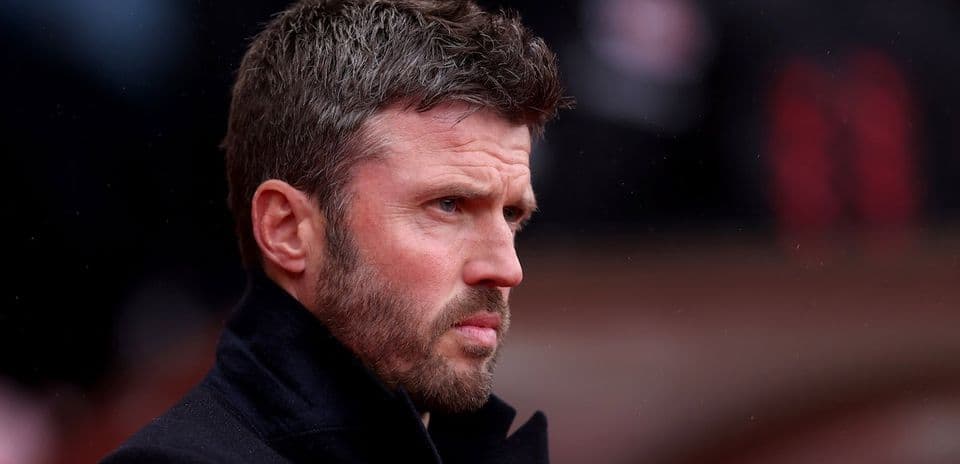 Man in black coat observing the match sidelines