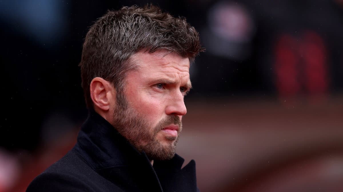 Man in black coat observing the match sidelines