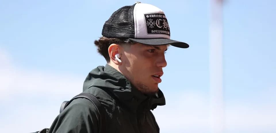 Player walking with hat and earbuds outdoors