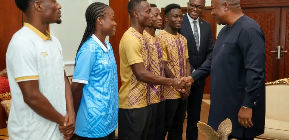 Athletes shaking hands with a dignitary in office
