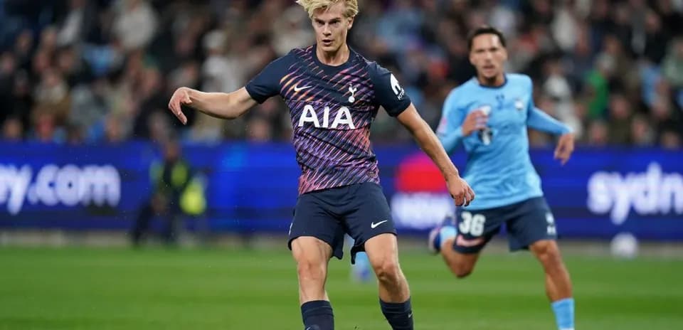 Player in Tottenham kit kicking the ball during match
