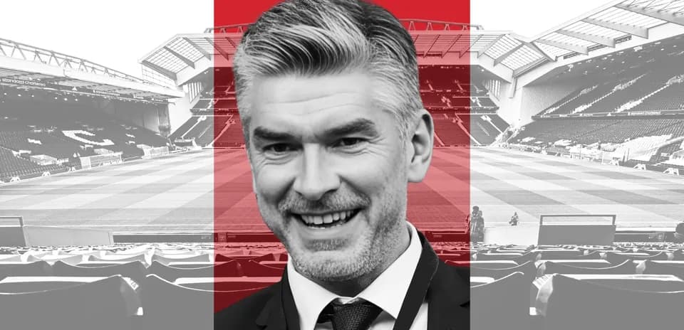 Smiling man in suit at football stadium