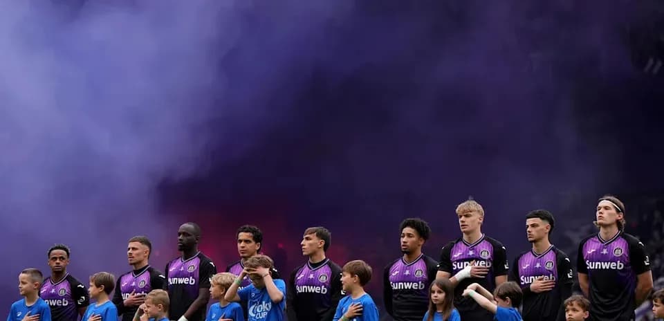 Players and children standing for anthem with smoke