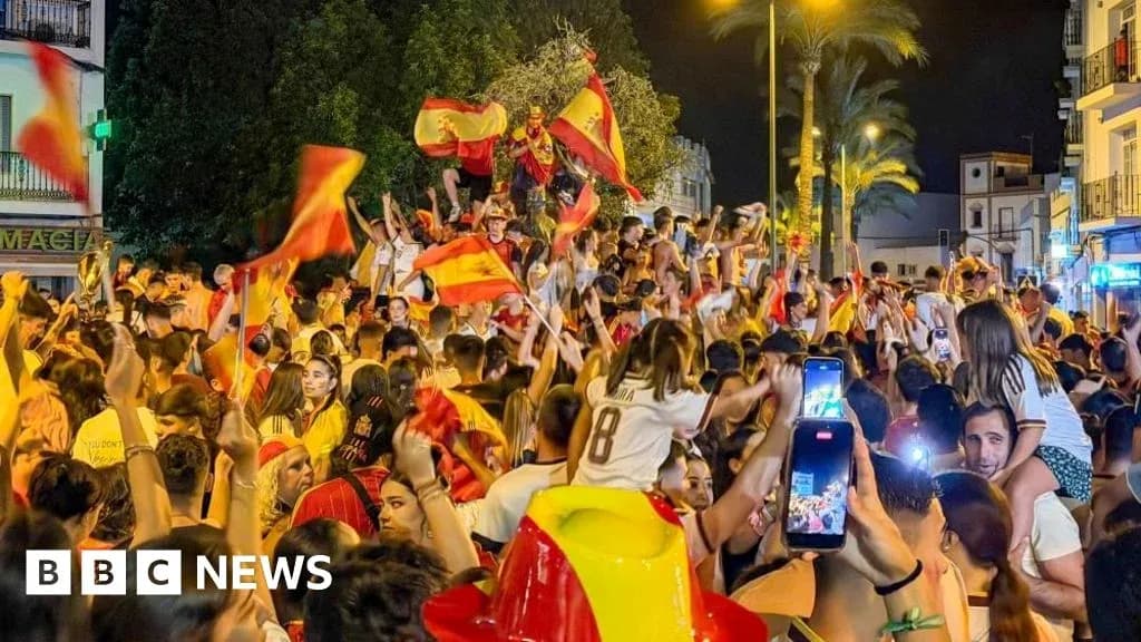 Crowd celebrating with flags in street at night