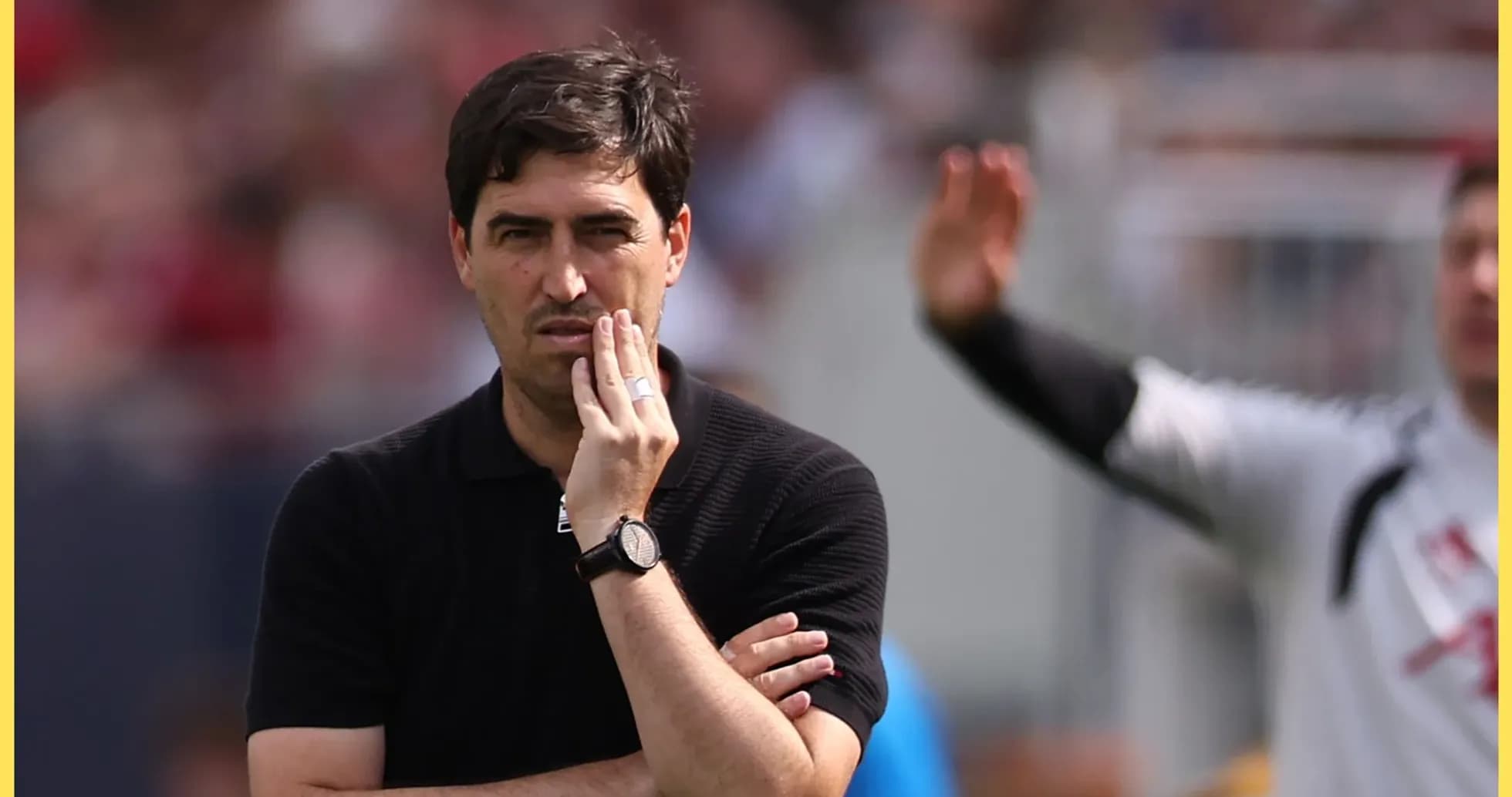 Coach observing match with thoughtful expression