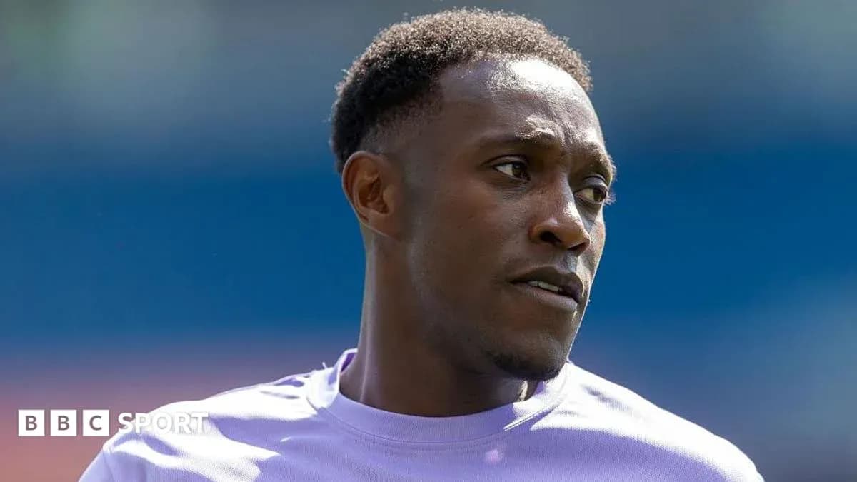 Football player in purple kit during warm-up