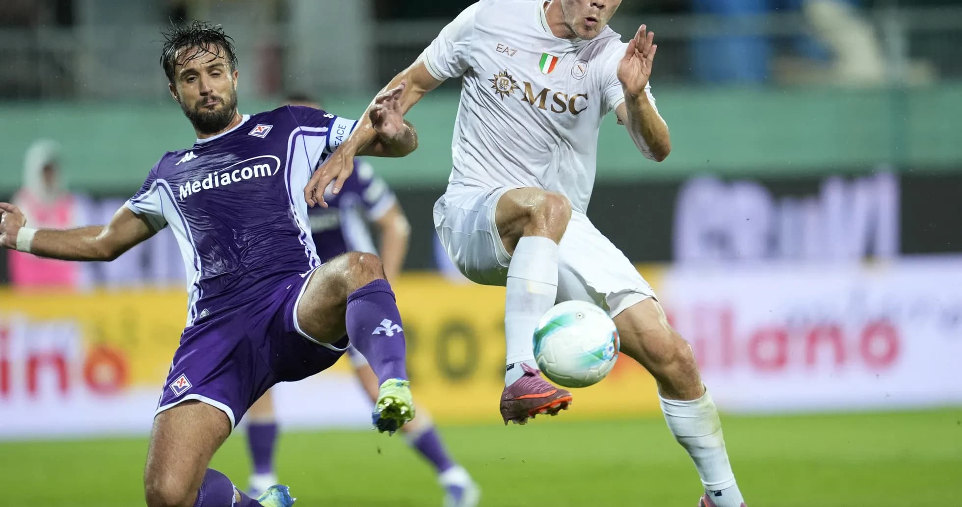 Fiorentina player challenges Napoli player for the ball
