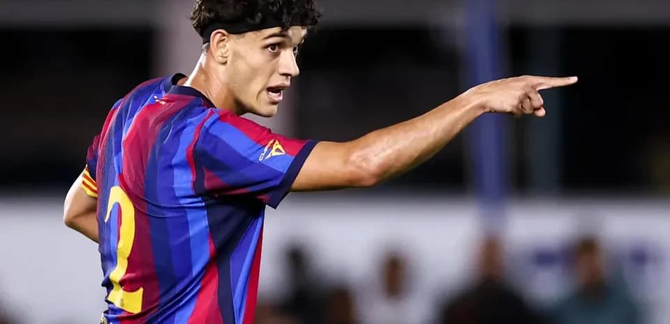 Player in FC Barcelona kit directing teammates on field