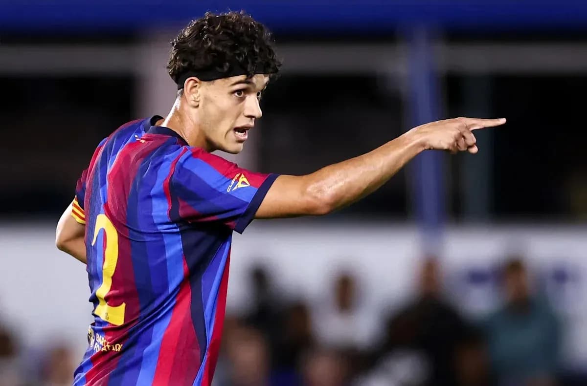 Player in FC Barcelona kit directing teammates on field