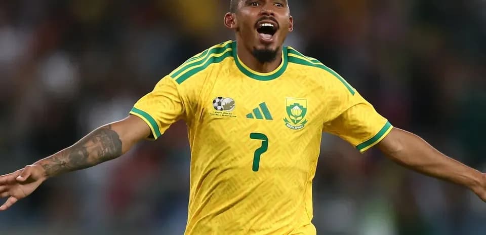 Player celebrating a goal in South Africa kit