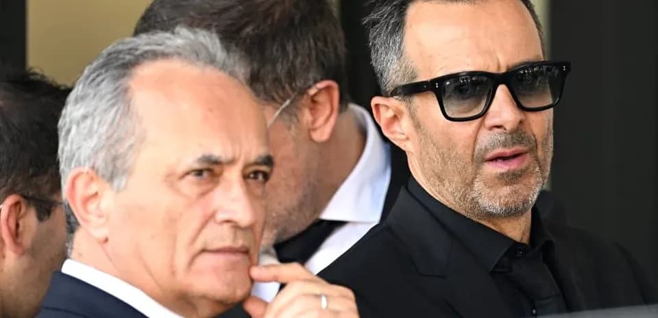 Two men in formal attire with sunglasses outdoors